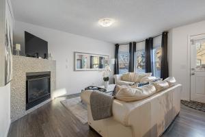 a living room with a couch and a fireplace at Modern House with Private Backyard & Fireplace in Calgary