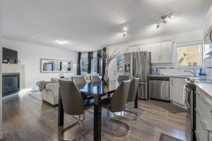a kitchen and dining room with a table and chairs at Modern House with Private Backyard & Fireplace in Calgary