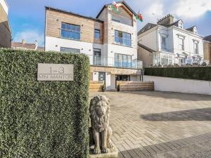a statue of a lion in front of a building at Bryn Min Manton Apartment in Caernarfon