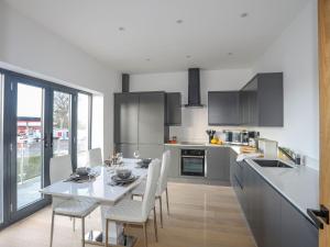 a kitchen with a table and chairs in a kitchen at Bryn Min Manton Apartment in Caernarfon