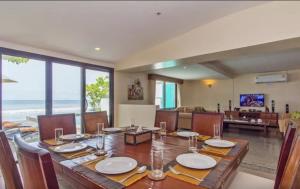 a dining room with a table and a living room at Goodwill Beach House in Patong Beach