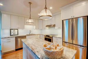 a kitchen with white cabinets and a granite counter top at Sea La Vie in Virginia Beach