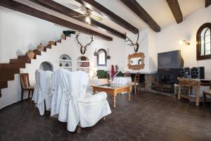 a living room with white chairs and a staircase at Cortijo Torreblanca - 12 personas in Almería