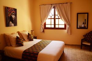 una camera con un grande letto e una finestra di Dar Essaada a Essaouira