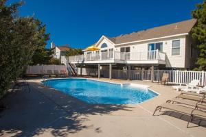 a swimming pool in front of a house at Coastal View VI in Virginia Beach