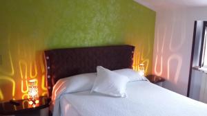 Un dormitorio con una cama blanca con dos luces. en Villa Giuliana, en Anguillara Sabazia
