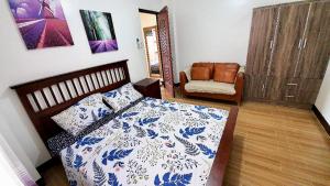 1 dormitorio con 1 cama y 1 silla en Kaitleen Home Stay Door 3, en Tacloban