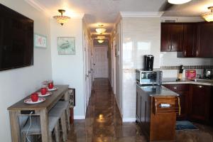 a kitchen with a table with red cups on it at Beachfront View Condo at Casa Del Mar in Galveston