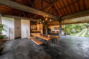 a large room with a large wooden table and benches at Village Bali in Uluwatu