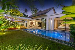 une villa avec une piscine la nuit dans l'établissement Labriz Ocean Villa Plus - Tropical Modern Living, à Thalang