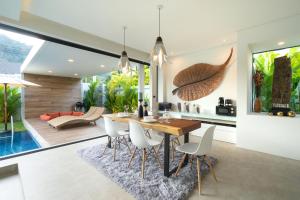 cocina y comedor con mesa y sillas en Labriz Ocean Villa Plus - Tropical Modern Living en Thalang