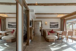 restauracja ze stołami i krzesłami oraz oknem w obiekcie The Lodge by Regina w Solden