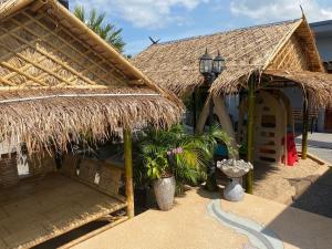 ein Gebäude mit einem Strohdach mit Pflanzen darin in der Unterkunft SB Holiday Resort Chiang Mai in Chiang Mai