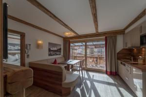 ein Wohnzimmer mit einem Sofa und einem Tisch sowie eine Küche in der Unterkunft Regina's Alpenlodge in Sölden