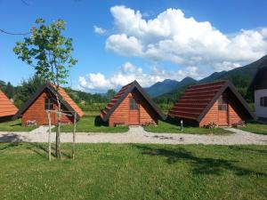 a group of wooden cabins with mountains in the background at Bungalows Rizvan City in Brušane