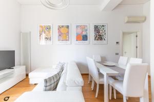 ein weißes Wohnzimmer mit einem weißen Tisch und weißen Stühlen in der Unterkunft Elena House Apartments in Viareggio