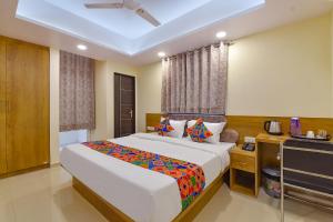 a bedroom with a large bed and a television at FabHotel Pink City in Jaipur