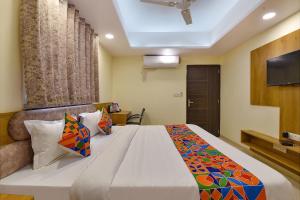 a bedroom with a large bed with a television on the ceiling at FabHotel Pink City in Jaipur
