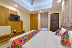 a bedroom with a large bed and a tv at FabHotel Pink City in Jaipur