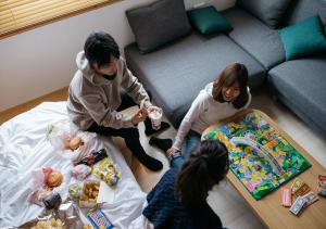 高山市にあるFAV HOTEL HIDATAKAYAMA Westの居間に座って食べ物を食べる子供たち
