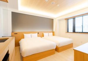 a bedroom with two beds and a window at fav Hida Takayama in Takayama