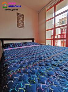 Una cama en una habitación con un edredón azul. en CASA ARMONIA SALENTO en Salento