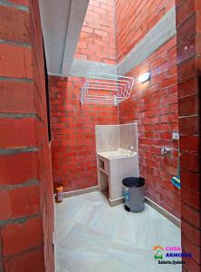 een badkamer van rode baksteen met een wastafel en een basketbalring bij CASA ARMONIA SALENTO in Salento