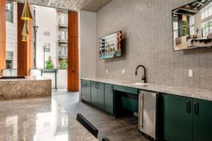a kitchen with green cabinets and a sink at Luxury Studio near DT Fort Worth in Fort Worth