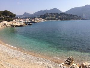 a beach with clear water and mountains in the background at La Piscine K6&You in Cassis