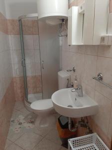 a bathroom with a toilet and a sink and a shower at Apartments Donadic I, Caska in Novalja