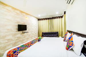 um quarto de hotel com uma cama e uma televisão em FabHotel Pride Inn em Hyderabad