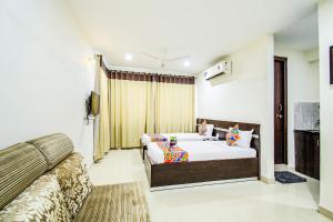 a bedroom with a bed and a couch at FabHotel Pride Inn in Hyderabad