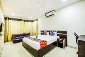 Pokój hotelowy z łóżkiem i krzesłem w obiekcie FabHotel Pride Inn w mieście Hajdarabad