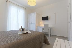 1 dormitorio con cama, mesa y TV en Scala Dei Turchi Resort, en Realmonte