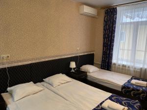 モスクワにあるKONCERT.RU™ HOTELのベッド2台と窓が備わるホテルルームです。