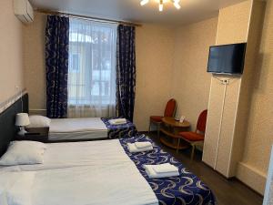 モスクワにあるKONCERT.RU™ HOTELのベッド2台、薄型テレビが備わるホテルルームです。