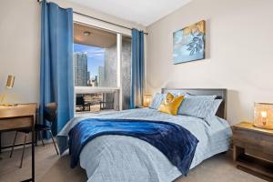 a bedroom with a bed and a desk and a window at Stylish Downtown Condos by GLOBALSTAY in Calgary