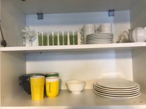a shelf filled with plates and cups and dishes at Crystalville Apartment 542 in Bakuriani +9 photos