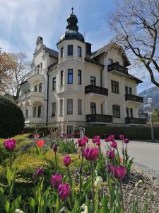 a large white house with flowers in front of it at Hotel Garni Steiermark in Bad Reichenhall