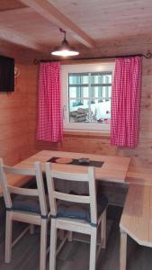 jadalnia ze stołem i krzesłami oraz oknem w obiekcie Tinyhouse Postalm w mieście Abtenau