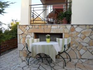 a table and chairs in front of a stone fireplace at Arcadian Apartments & Studios in Xiropigado