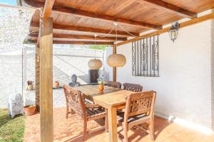 a wooden table and chairs on a patio at Villa Jardin Tropical in Manilva