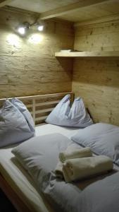 a large white bed in a wooden room at Tinyhouse Postalm in Abtenau