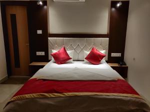 a bedroom with a large bed with red pillows at Hotel Benaras Gharana Inn in Varanasi
