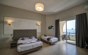 una camera d'albergo con due letti e un balcone di Europa Hotel a Sliema