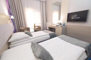 ein Hotelzimmer mit 3 Betten und einem Flachbild-TV in der Unterkunft Alabaster Rezydencja in Rzeszów
