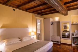 una camera con un grande letto di Hotel Boutique Antiche Mura a Saluzzo