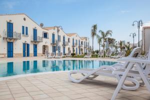 uma piscina com cadeiras e uma villa em Scala Dei Turchi Resort em Realmonte