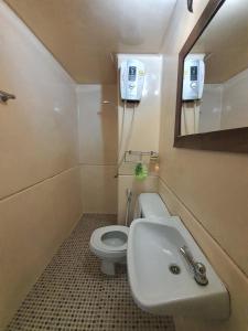 a bathroom with a toilet and a sink and a mirror at Great Location At IMPACT ARENA Muang Thong Thani C3 in Pak Kret
