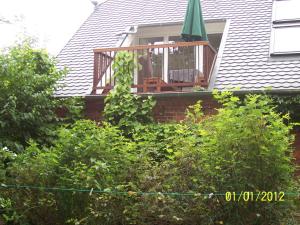 a house with a porch with a deck and a balcony at Schrotboden in Geschendorf